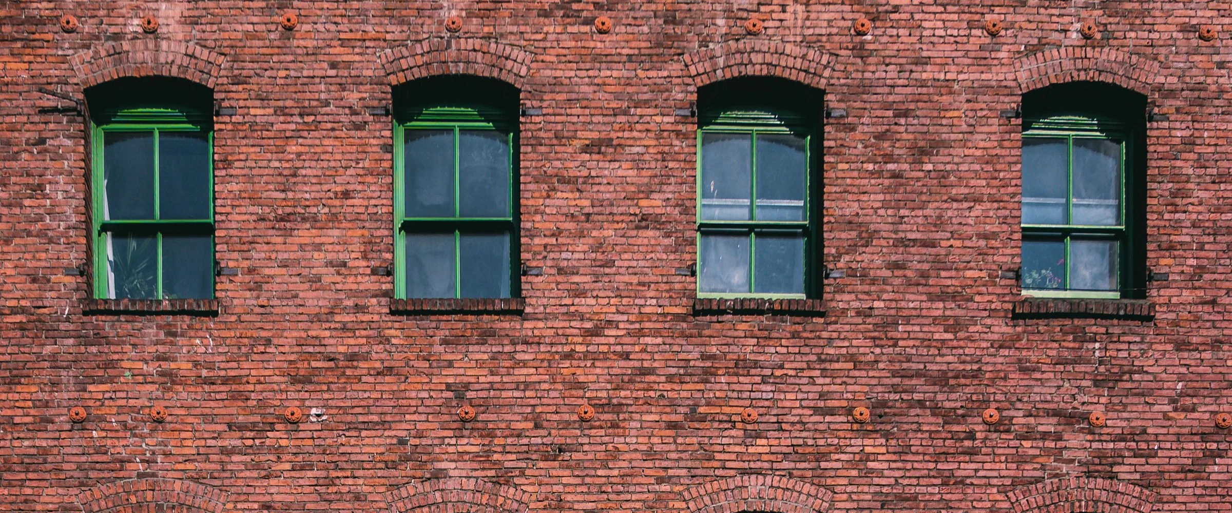 A red brick building with green-framed windows