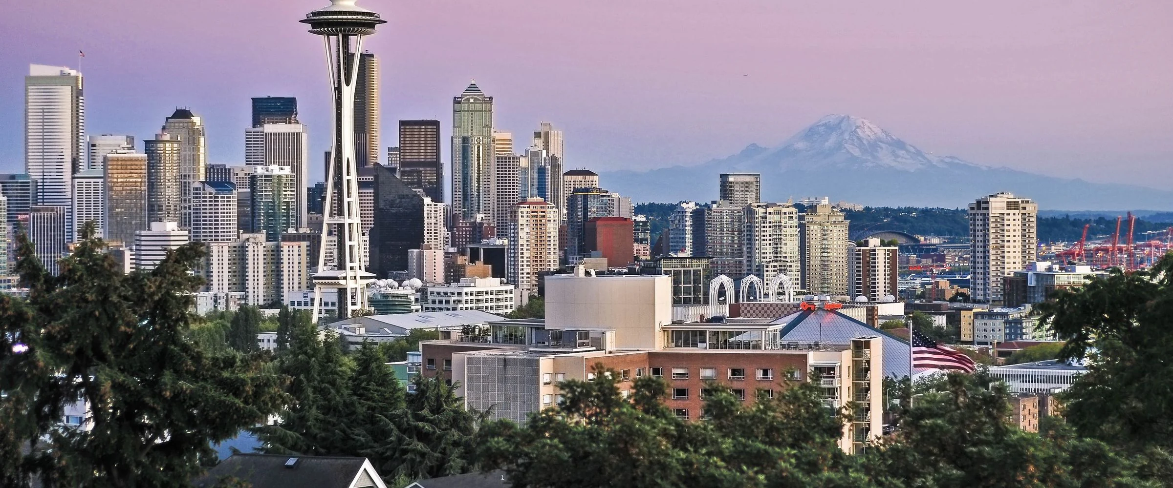 The Seattle skyline with the Space Needle and Mount Rainier at dusk